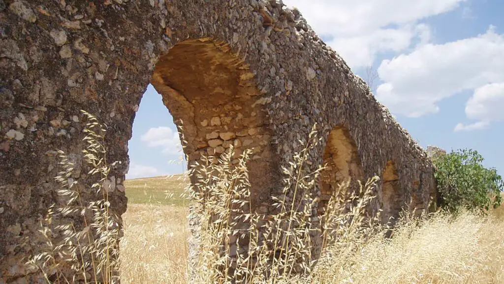 Acuaducto romano en un campo repleto de trigo, las funciones de los ediles incluían mantener los edificios públicos.